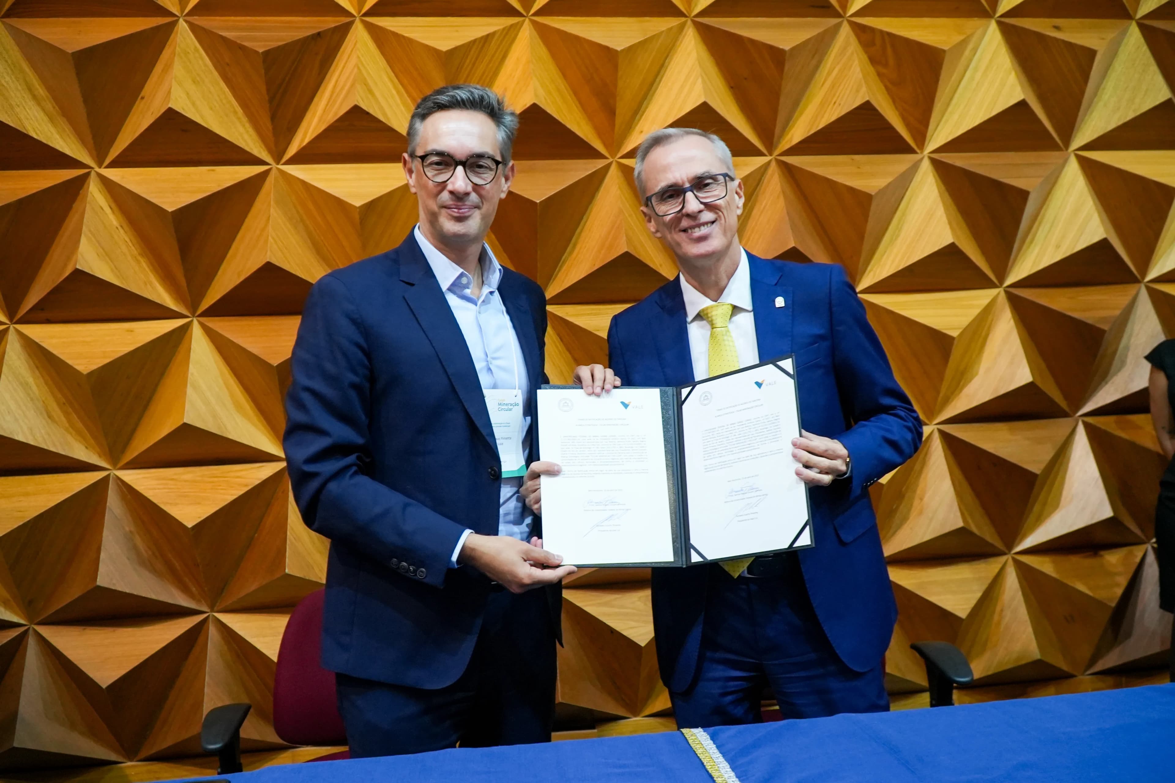 Representantes da Vale e da UFMG segurando o termo de aliança estratégica assinado